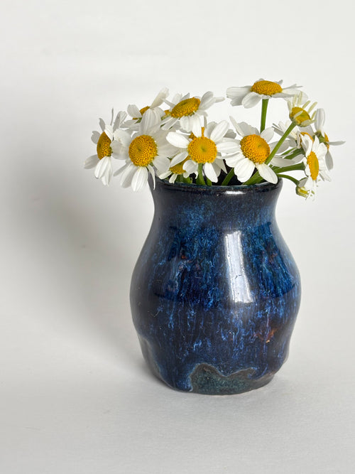 A small dark blue glossy vase in a miniature size. 